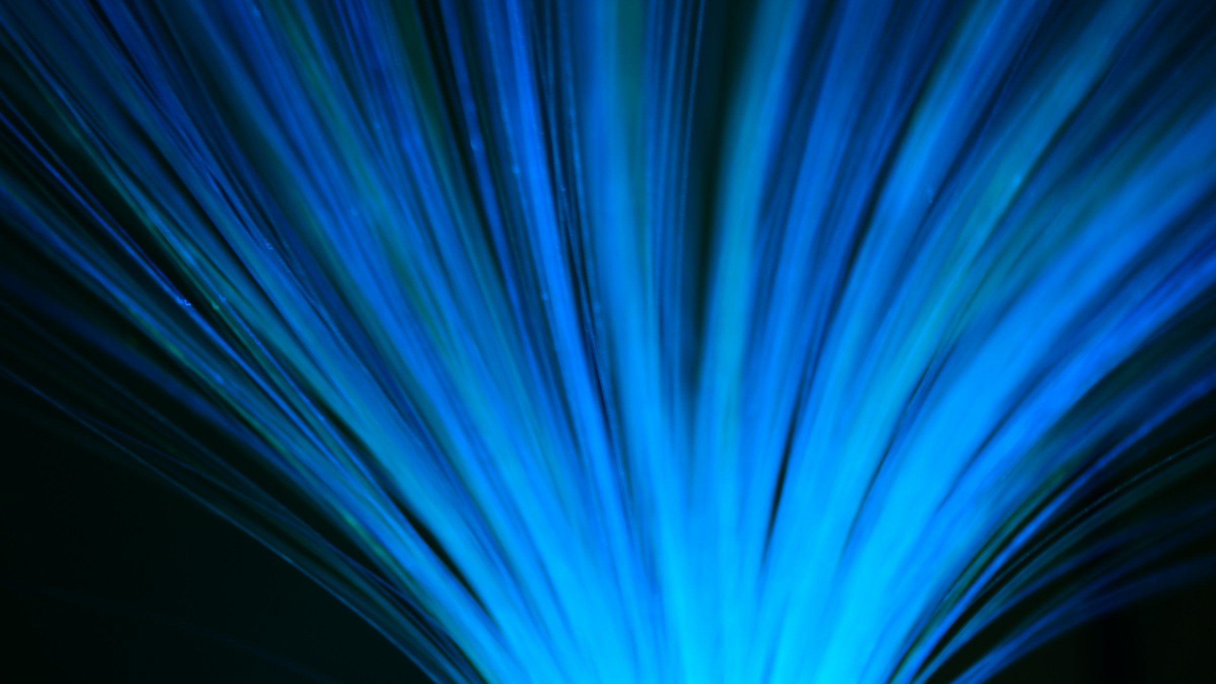 Blue fibre-optic strands fanning outwards against a dark background