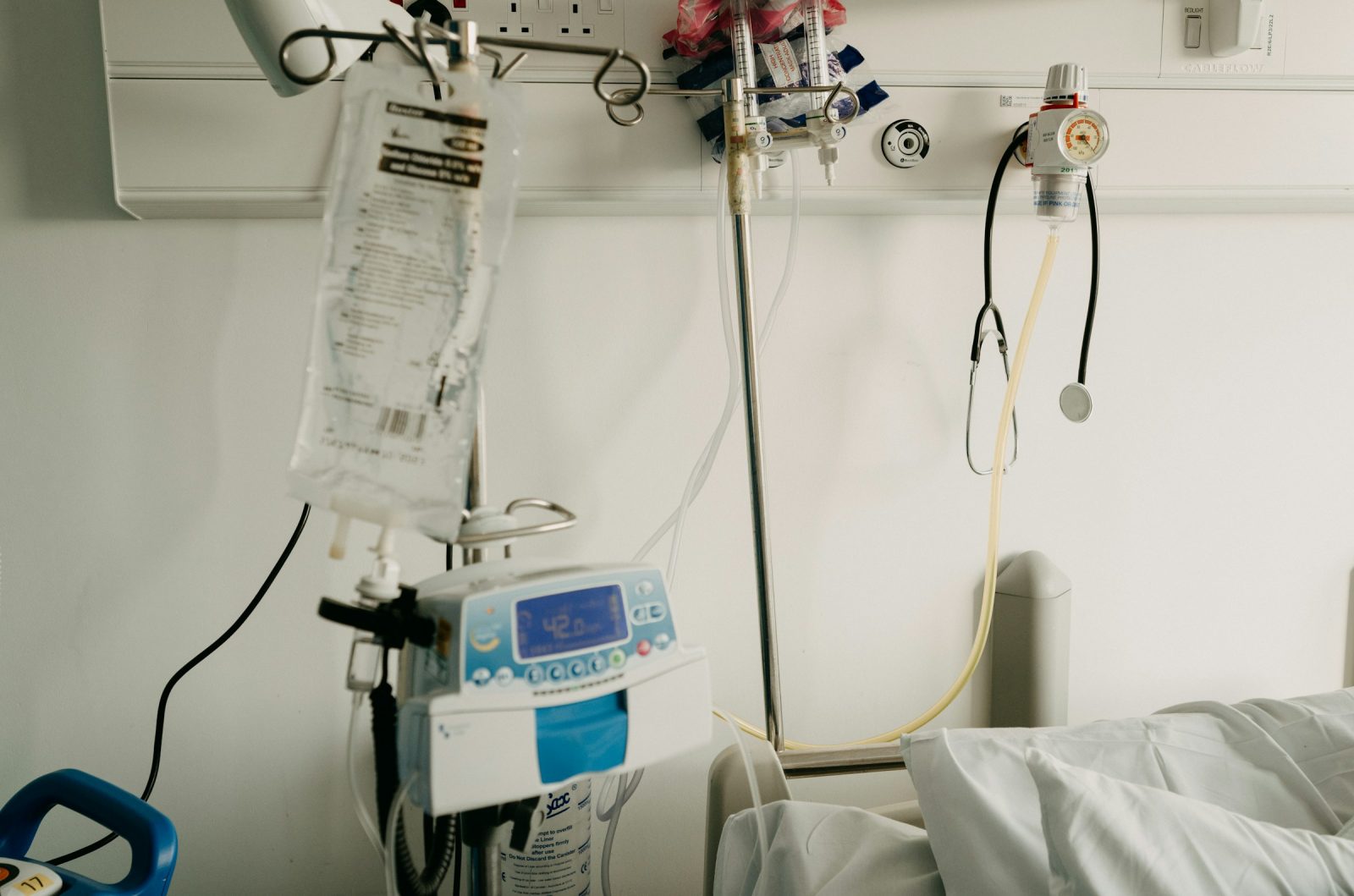 A tidy hospital room with a bed and monitoring equipment