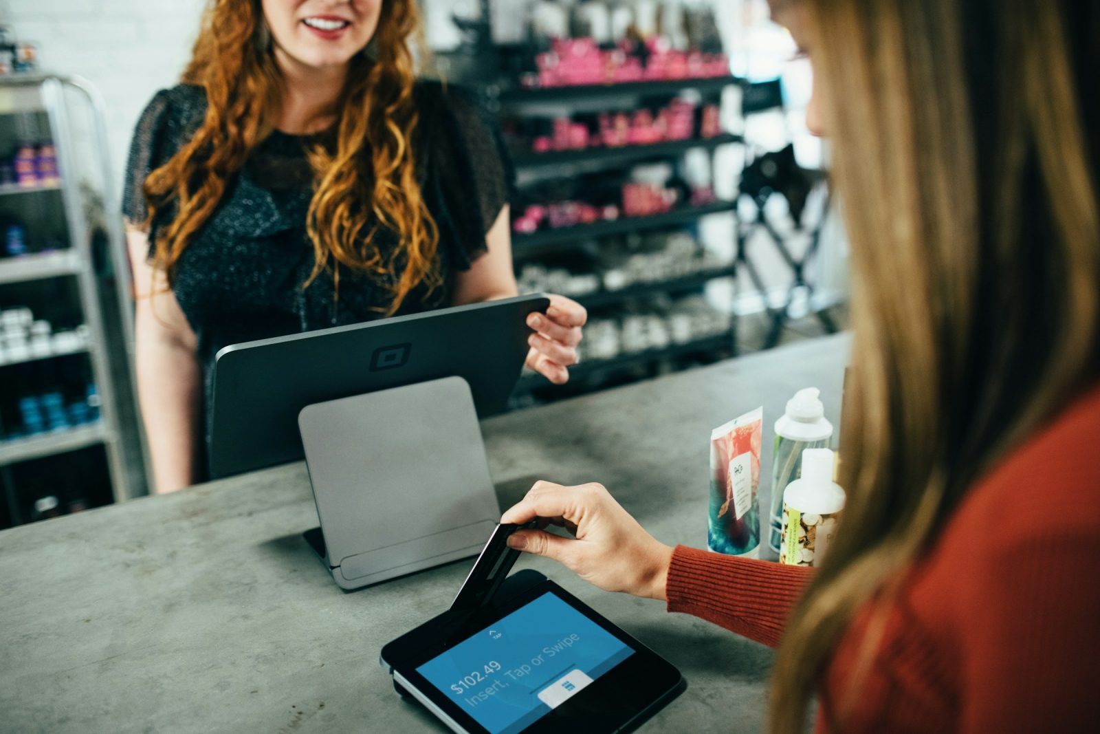 A customer paying by card at a shop counter